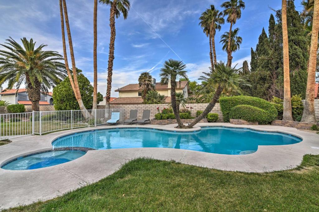 a swimming pool in a yard with palm trees at Las Vegas House with Pool and Hot Tub - 1 Mi to Strip! in Las Vegas