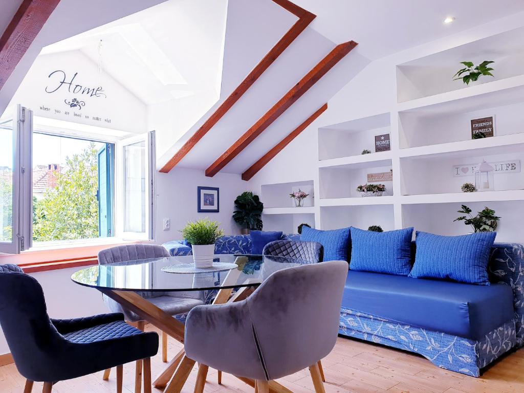 a living room with a blue couch and a glass table at Apartments Sandra in the historical center of the city in Supetar