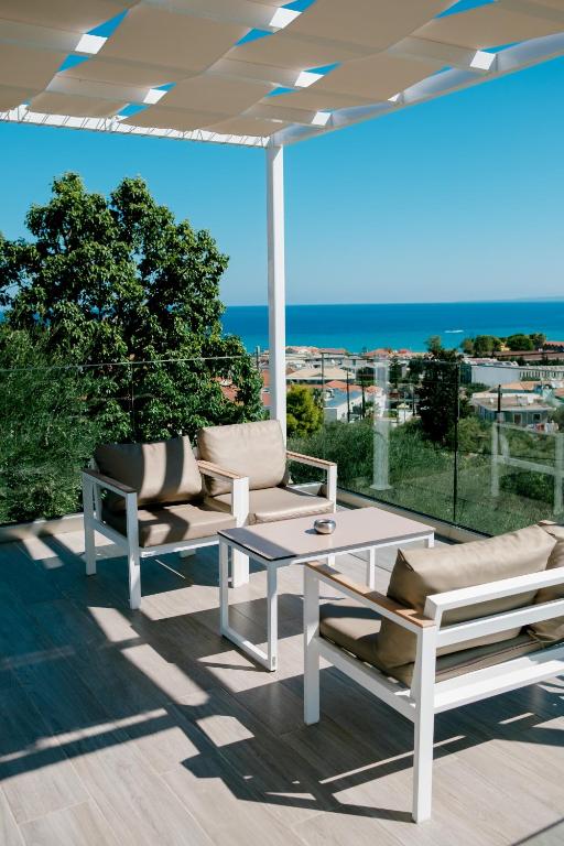 a patio with a table and chairs and an umbrella at CasAlma II in Tsilivi