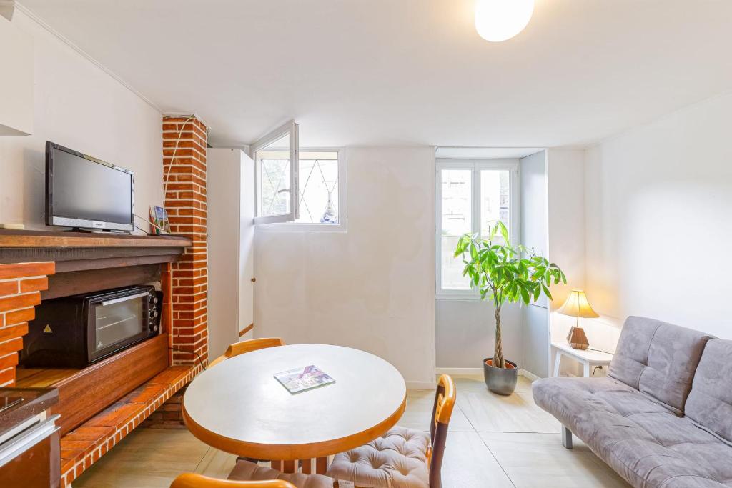 un salon avec une table et un canapé dans l'établissement Le Doolie's Hostel B&B - El Nido - Jardin - Wifi - VOD, à Biarritz