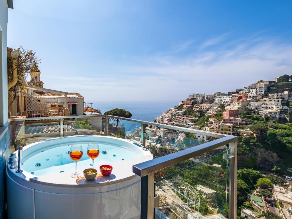balkon z wanną z hydromasażem i 2 kieliszkami wina w obiekcie Santoro Suite w mieście Positano