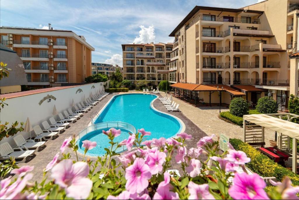 vistas a una piscina con sillas y flores en Rose Village - Private apartment - BSR - 1 en Sunny Beach