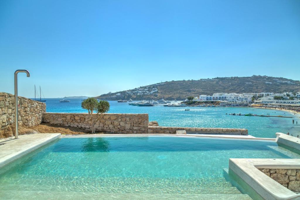 a swimming pool with a view of the ocean at The Absolute beachfront luxury villa in Platis Yialos Mykonos