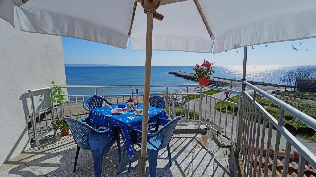 帕莫瑞的住宿－Nikolovi Home Apartments，阳台配有带椅子和遮阳伞的蓝色桌子