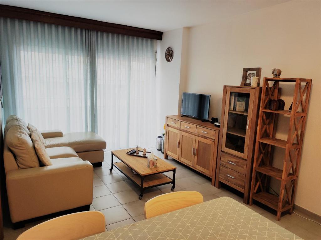 ein Wohnzimmer mit einem Sofa und einem TV in der Unterkunft Lovely apartment in Calafell