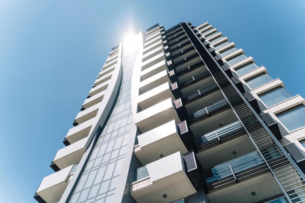 um edifício de apartamentos alto com o sol no céu em Top location,Sea ​​View and luxury apartments in Symphony residence em Varna City