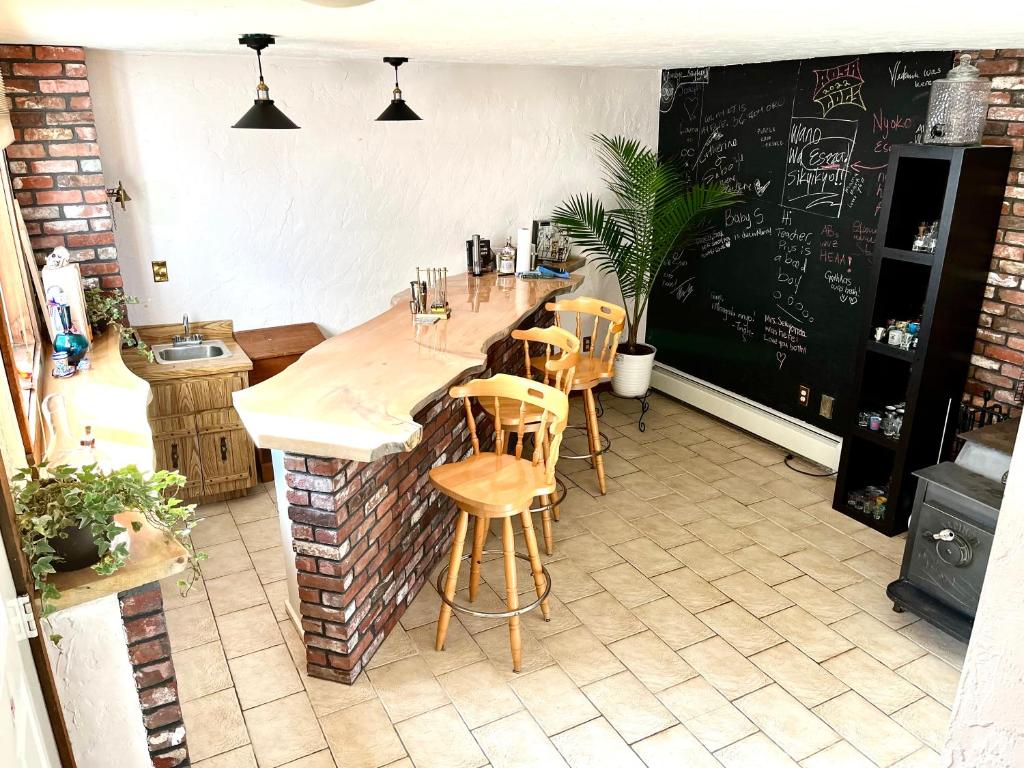 a kitchen with a bar with chairs and a chalkboard at Daybed with trundle - access to home library & bar in Revere