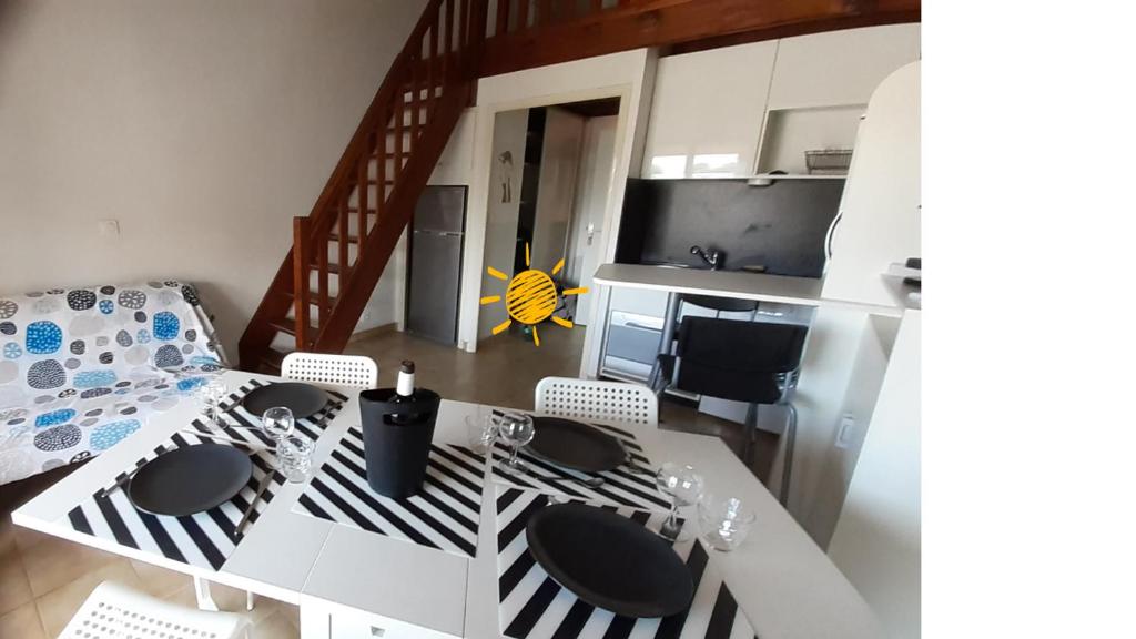 une cuisine avec une table et des chaises dans une pièce dans l'établissement Appartement terrasse vue mer, plage gorguette à 1 minute à pied, wifi,clim parking collectif, à Sanary-sur-Mer