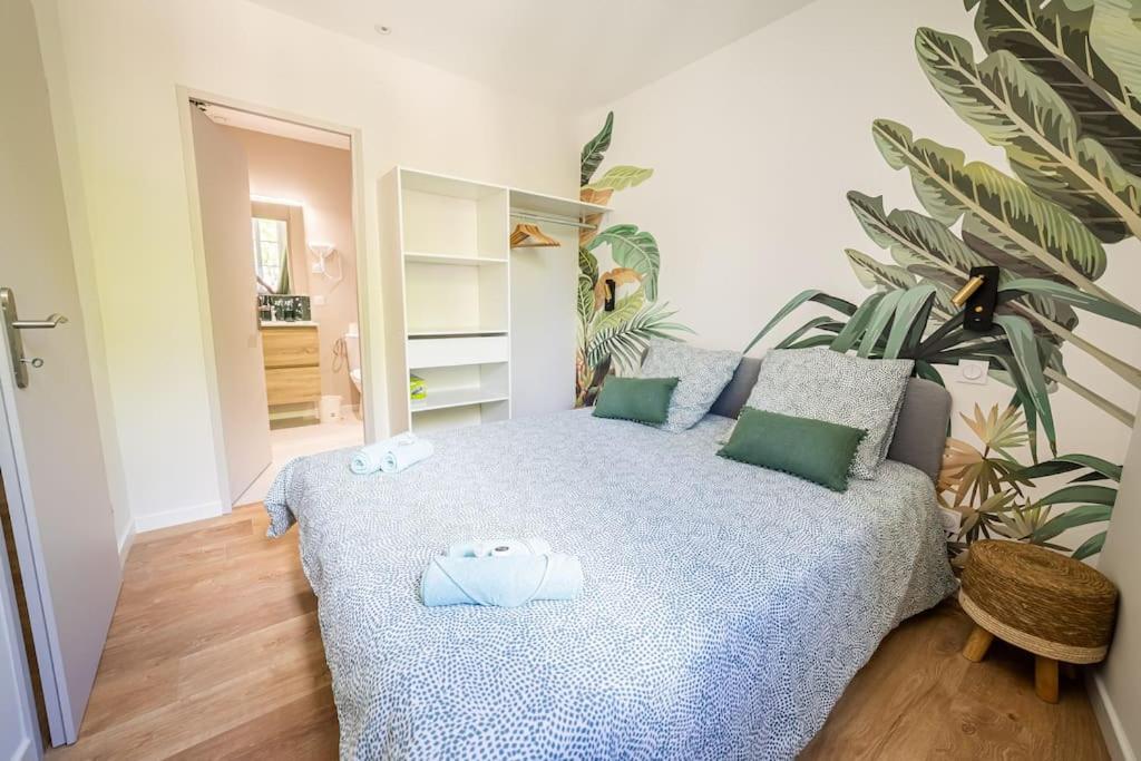 a bedroom with a bed and a plant at Le Pearl Appartement de charme en bord rivière in Collobrières