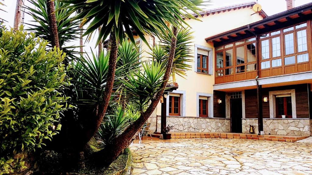 uma casa com palmeiras em frente em Villa Natalia Loft Rural em Llanes