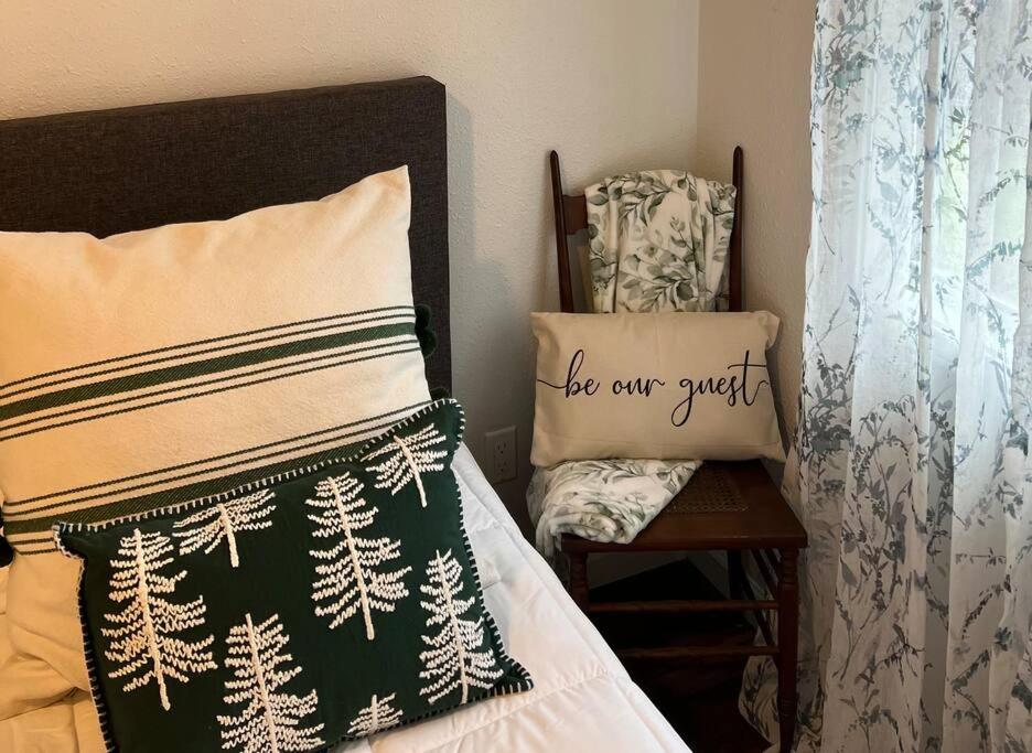 a bedroom with a bed with a pillow and a chair at Cozy Getaway at Lake O' the Pines in Ore City