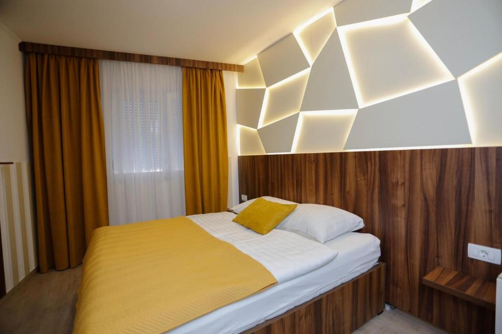 um quarto com uma cama com um cobertor amarelo em Hotel - Villa Lejla em Mostar