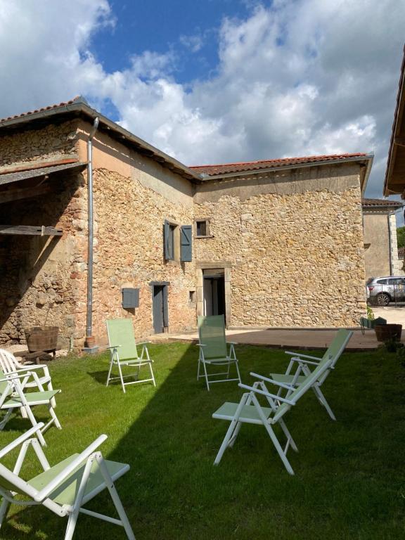 a group of lawn chairs in front of a building at La vieille forge in Boussan