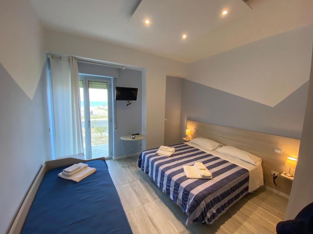 a bedroom with a bed with two towels on it at NARANJA in Marina di Schiavonea