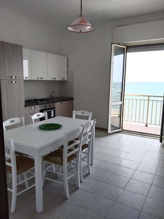 a kitchen and dining room with a white table and chairs at Olga’s house in Cariati