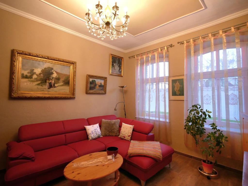 a living room with a red couch and a table at Märchenhaft urlauben auf dem Alpakahof in Rambow