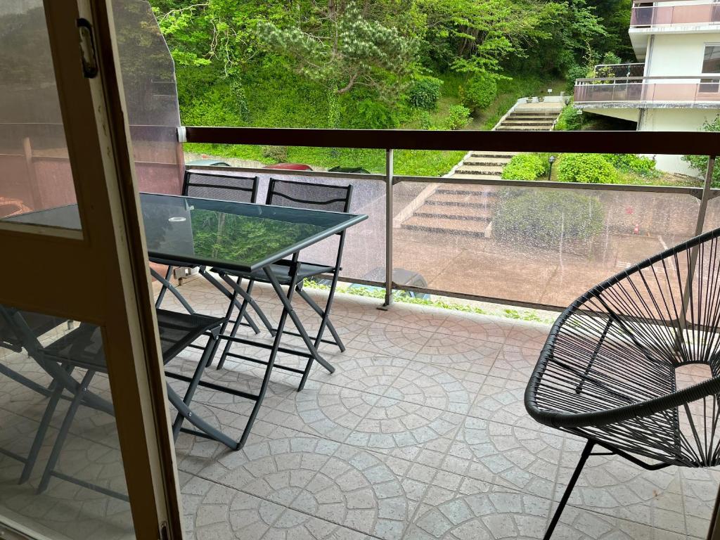 a balcony with a table and chairs on a patio at Hauteurs de Trouville - Studio avec terrasse au calme in Trouville-sur-Mer