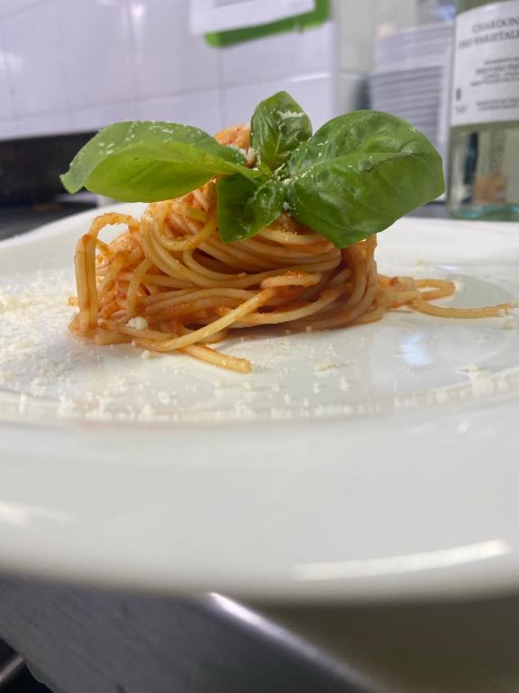 talerz makaronu z zieloną rośliną na górze w obiekcie Hotel Capri w mieście Diano Marina