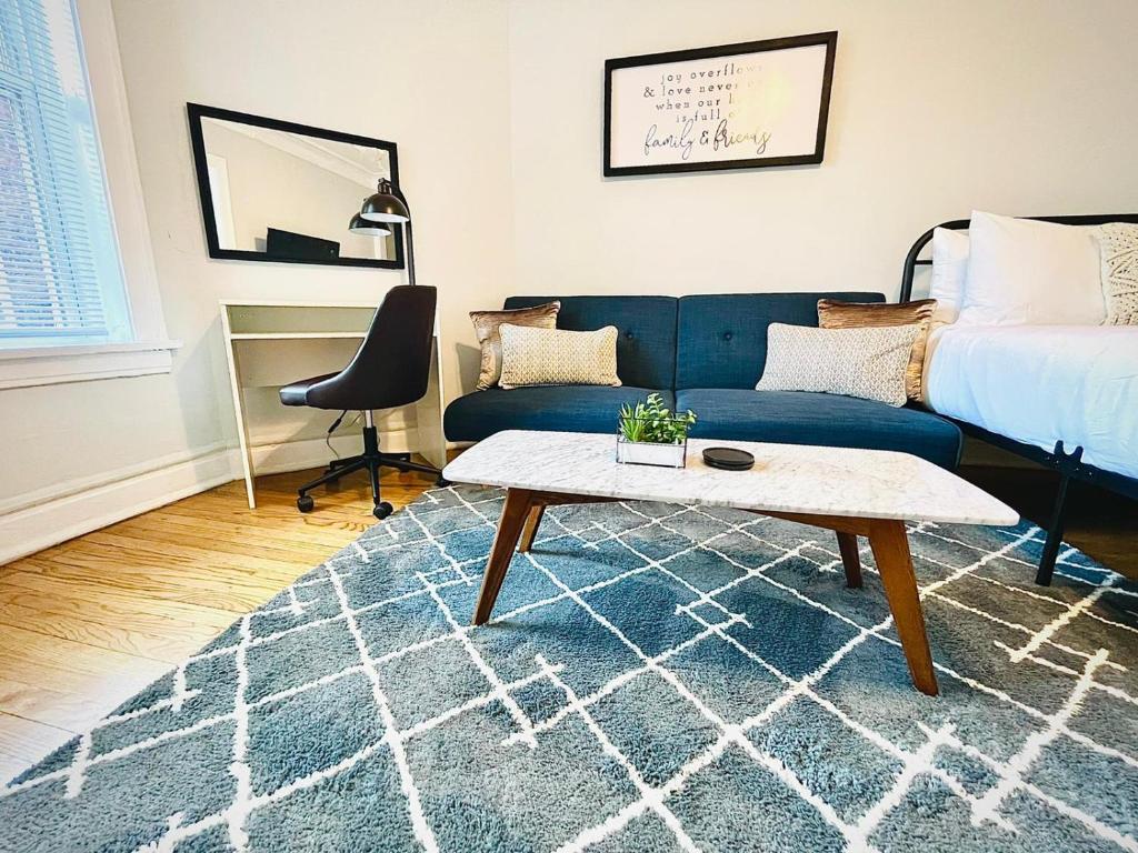 Una sala de estar con un sofá azul y una mesa. en City Charm Studio Apt close to Shops - Ashland 04, en Chicago