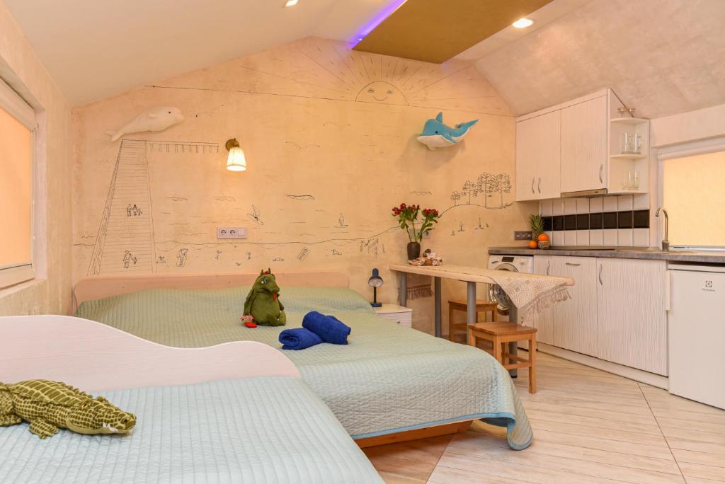 um quarto com duas camas e uma mesa e uma cozinha em INKARAS Aparthotel em Palanga