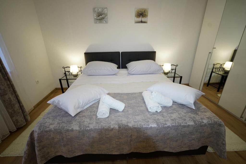 1 dormitorio con 1 cama con sábanas blancas y calcetines blancos en Apartment Ana en Split