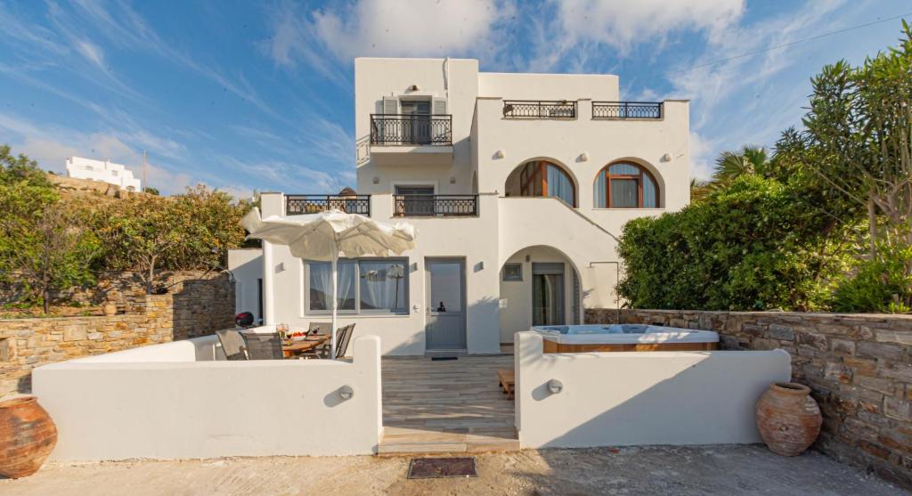 a white house with a swimming pool in front of it at Villa Di Sergio in Glinado Naxos