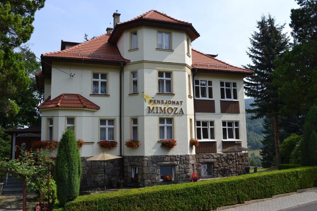 un gran edificio blanco con techo rojo en Pensjonat Mimoza, en Świeradów-Zdrój