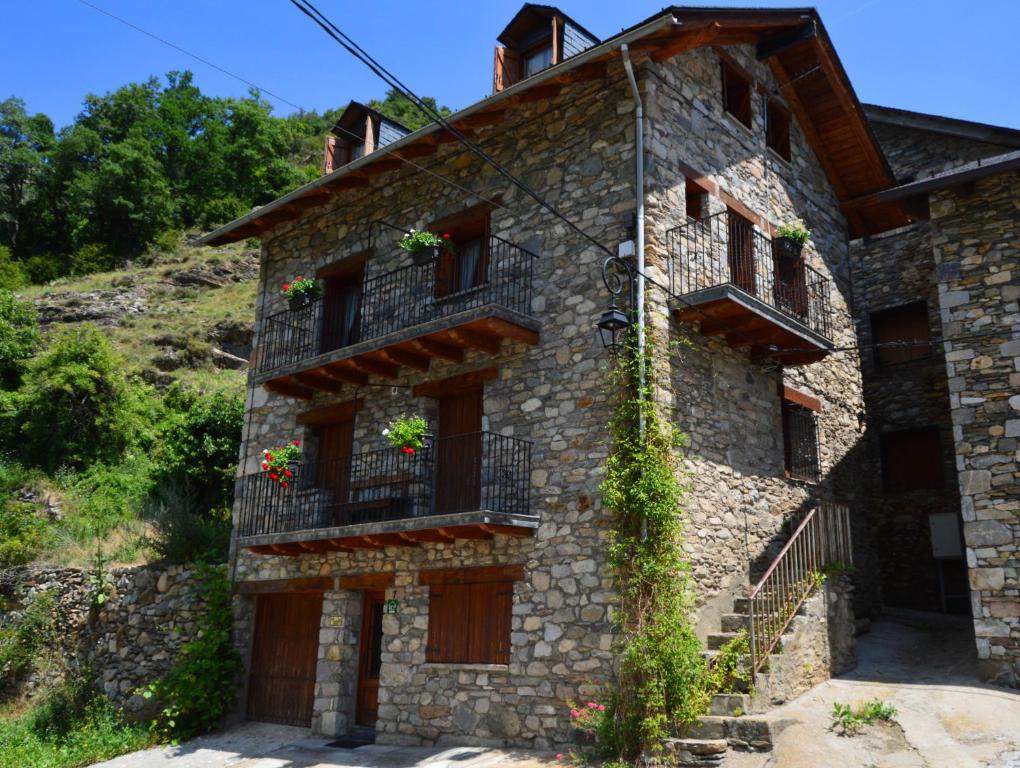 an old stone building with flowers on the balconies at Casa Torellola in Cardet