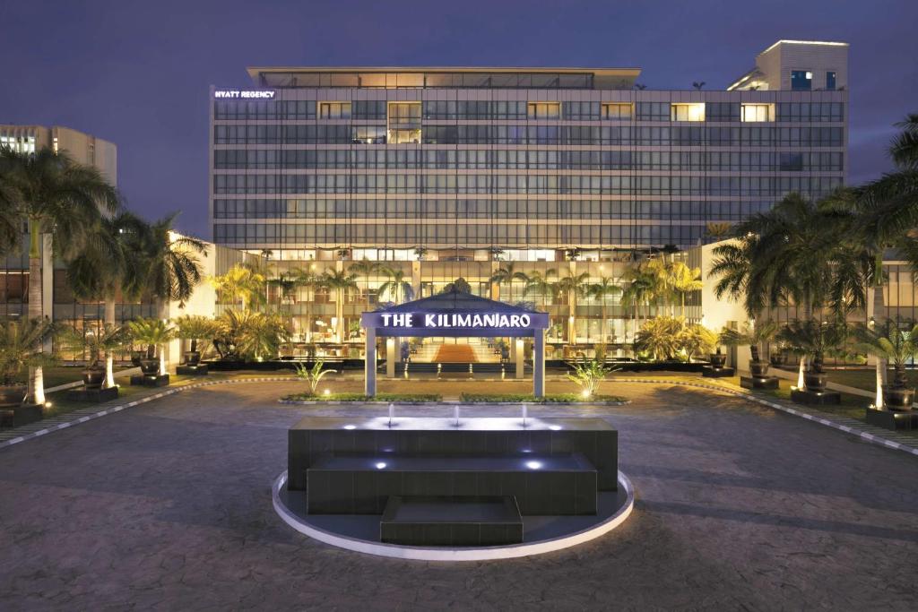 ein großes Gebäude mit einem Schild davor in der Unterkunft Hyatt Regency Dar es Salaam, The Kilimanjaro in Daressalam