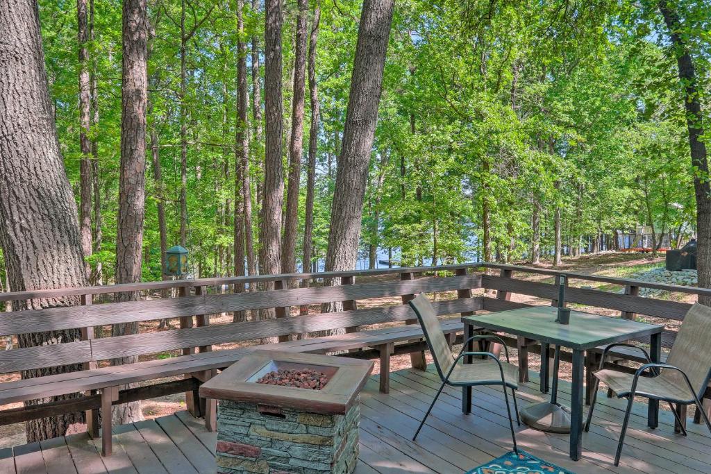 a wooden deck with a picnic table and chairs at Quaint Tignall Cabin with Deck and Private Dock! in Tignall
