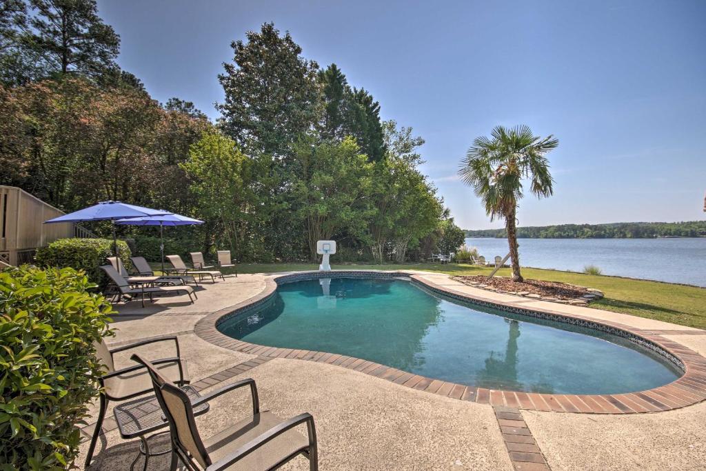 Impeccable Home with Dock and Pool on Lake Wateree! في كامدن: مسبح مع كراسي وإطلالة على بحيرة