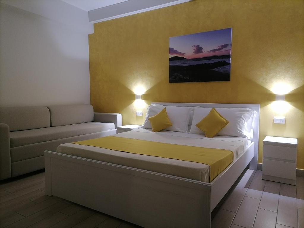 ein kleines Schlafzimmer mit einem Bett und einem Sofa in der Unterkunft B&B La Casa Du Barone in Falcone