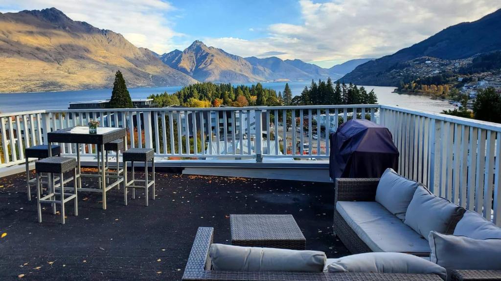 a patio with a couch and a table on a balcony at Lakeview with amazing Rooftop with 10mins walk to town镇上湖景三室套房 in Queenstown