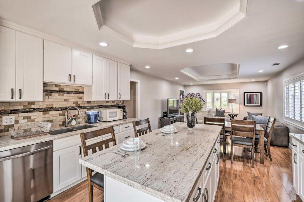una cocina con armarios blancos y una mesa con sillas. en Family Home in Walkable Area Near Silicon Valley!, en Campbell