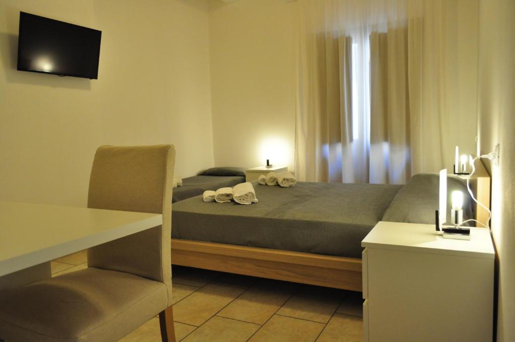 a bedroom with a bed with a table and a desk at Rooms and Breakfast Zefiro in San Vito lo Capo