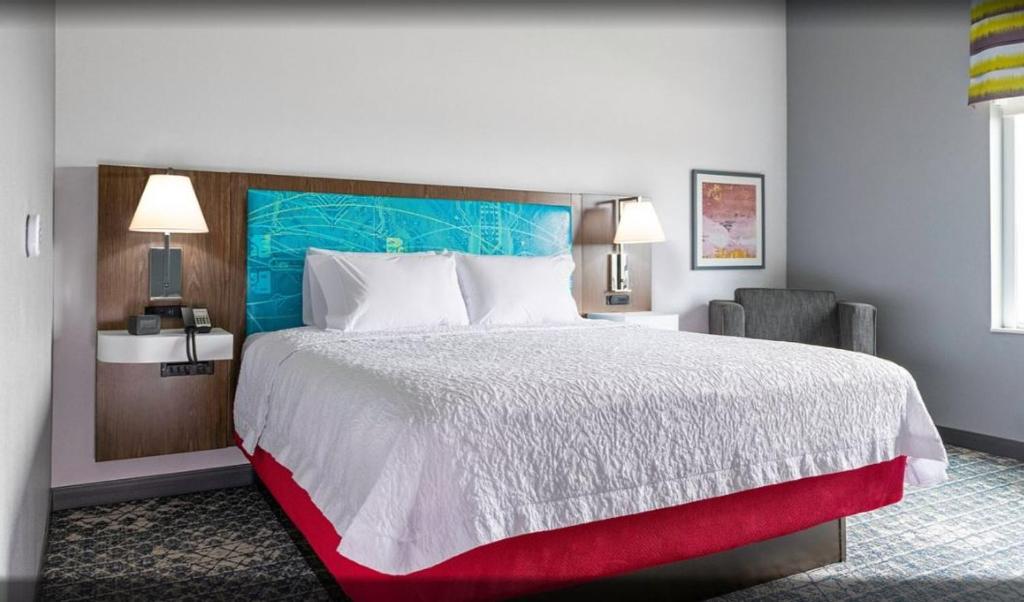 拉瓦卡港Hampton Inn & Suites Port Lavaca, Tx的配有一张大床和一把椅子的酒店房间