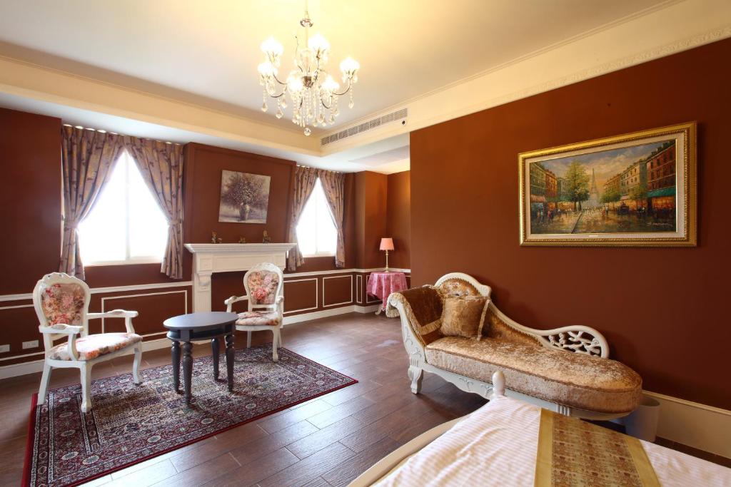 a bedroom with a couch and chairs and a chandelier at Haut Rhin Villa in Zhuangwei