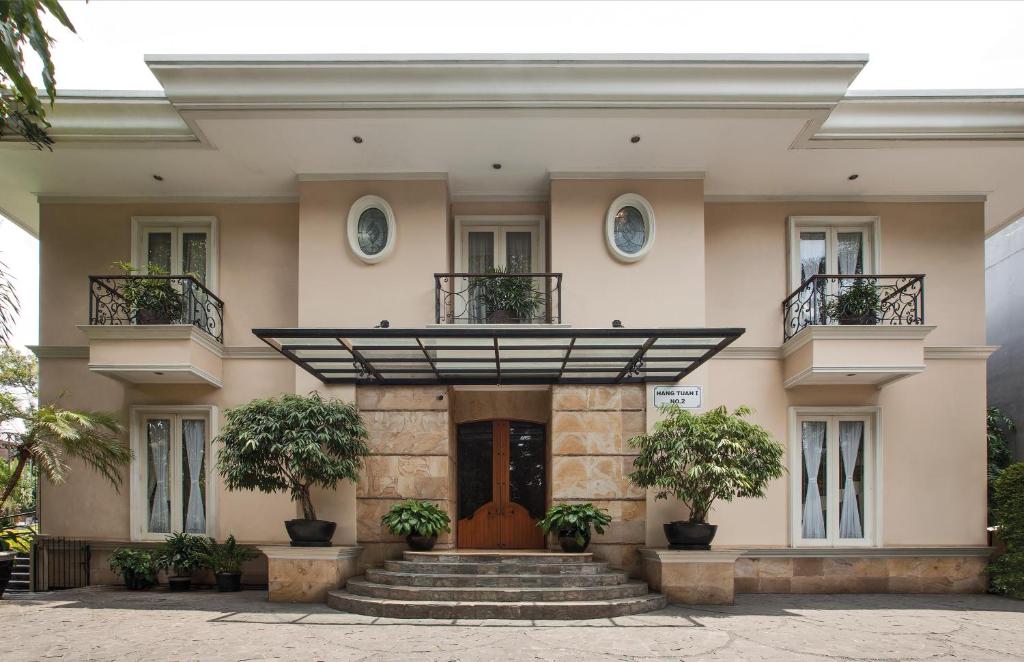 um edifício com escadas e vasos de plantas em frente em ARTOTEL Casa Hangtuah em Jacarta