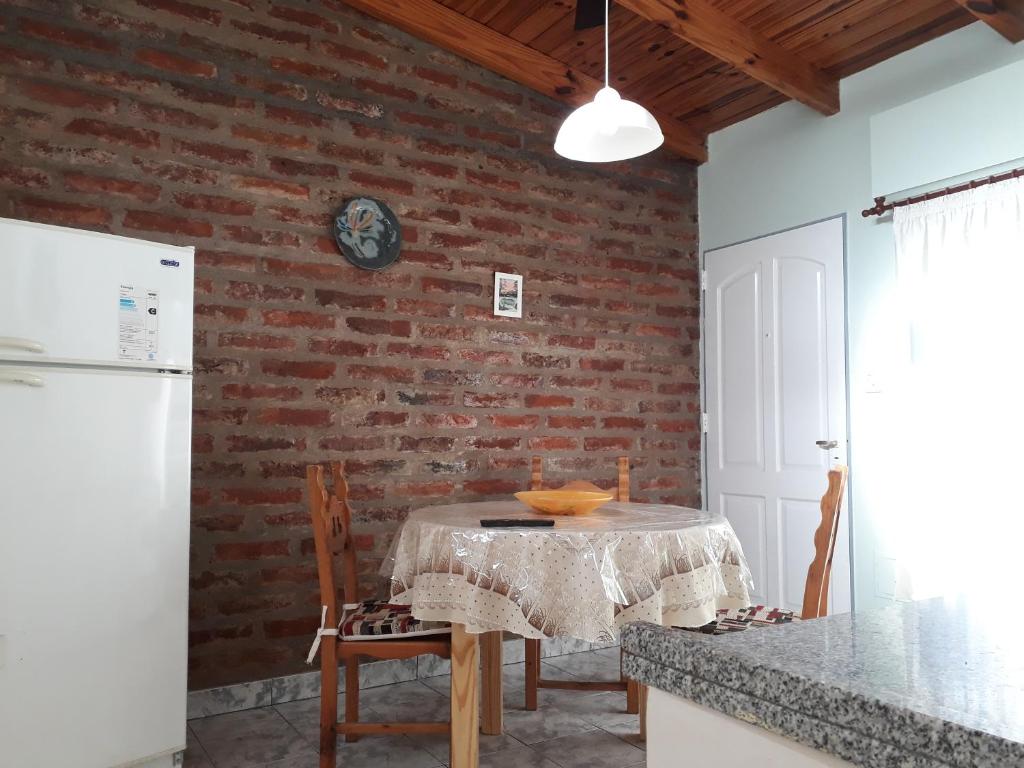 a kitchen with a table and a brick wall at San Cayetano Departamento por dia con cochera gratis in Bahía Blanca