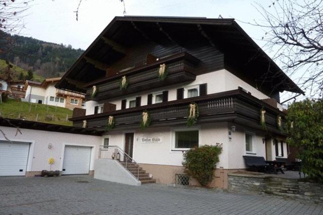 una gran casa blanca con techo de gambrel en Pension Mühle, en Zell am See