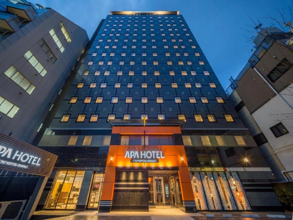 um edifício alto com o Hotel Rhode em APA Hotel TKP Nippori Ekimae em Tóquio