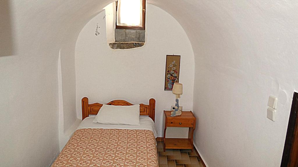 a small bedroom with a bed and a table at Karampela Despina in Mestá