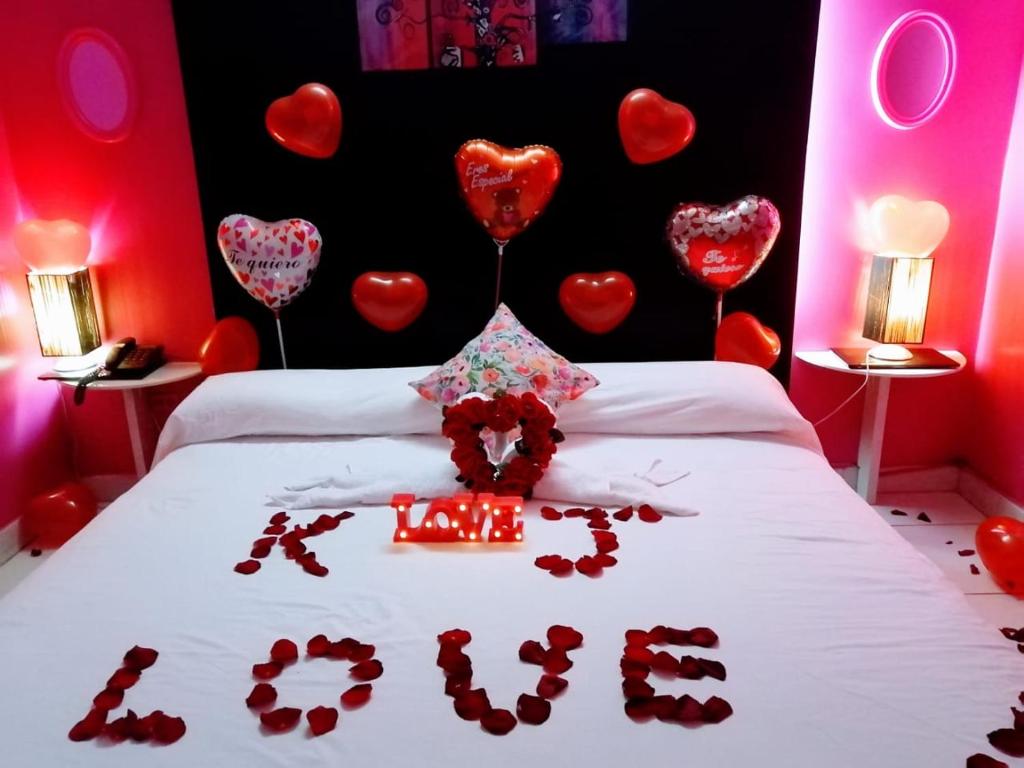 Un dormitorio con corazones rojos en la pared y una cama. en Stylus Hotel, en Iquitos