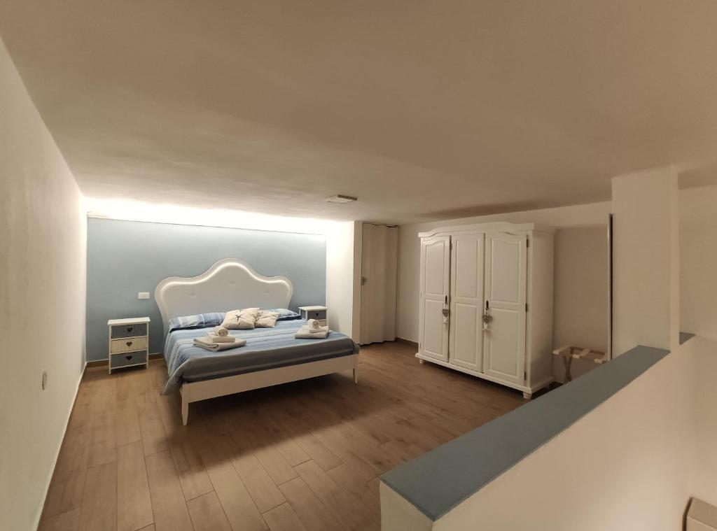 ein Schlafzimmer mit einem Bett und einem weißen Schrank in der Unterkunft Minù in Gaeta