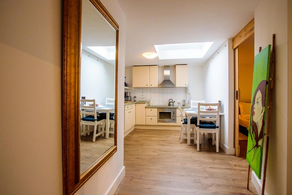 a kitchen with a mirror and a dining room at Prachtig gerenoveerd bakhuis EneRené in Vught