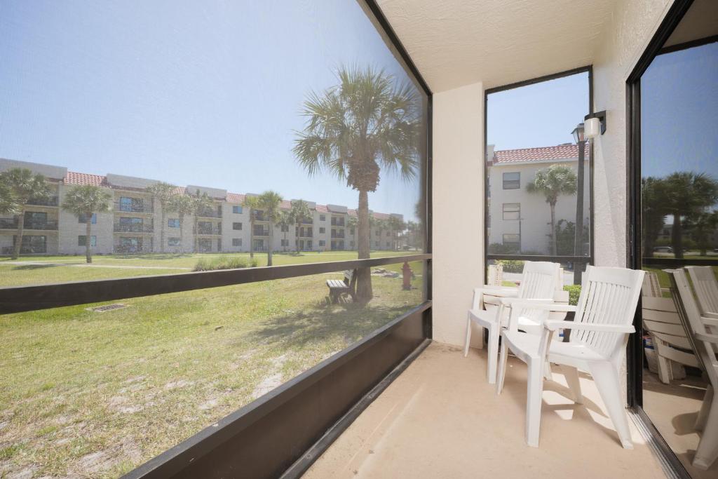 einen Balkon mit einem Tisch, Stühlen und einer Palme in der Unterkunft Ocean Village Club Q11, 2 Bedrooms, Sleeps 6, Ground Floor, Pet Friendly in St. Augustine