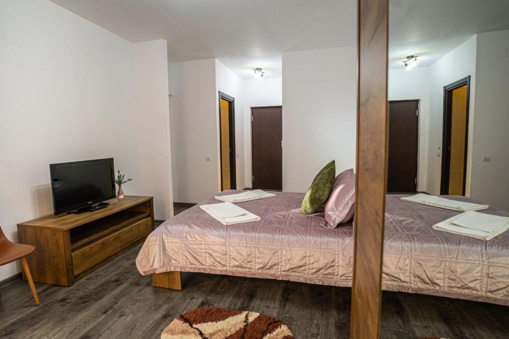 Una pequeña habitación con una cama y un televisor. en Seasons Primab Studio, en Brasov