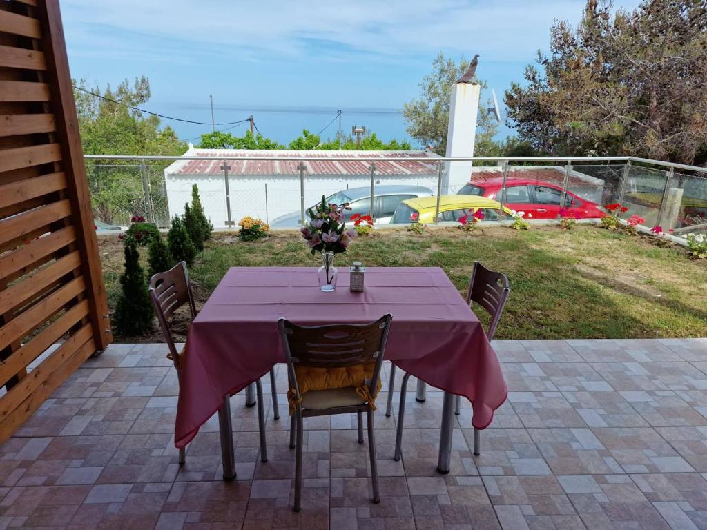 une table avec un chiffon de table violet sur une terrasse dans l'établissement SOLYMAR PRIVE, à Archangelos