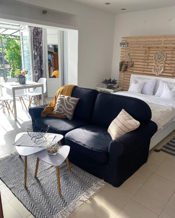 a living room with a blue couch and a bed at Green garden in Žarkovo