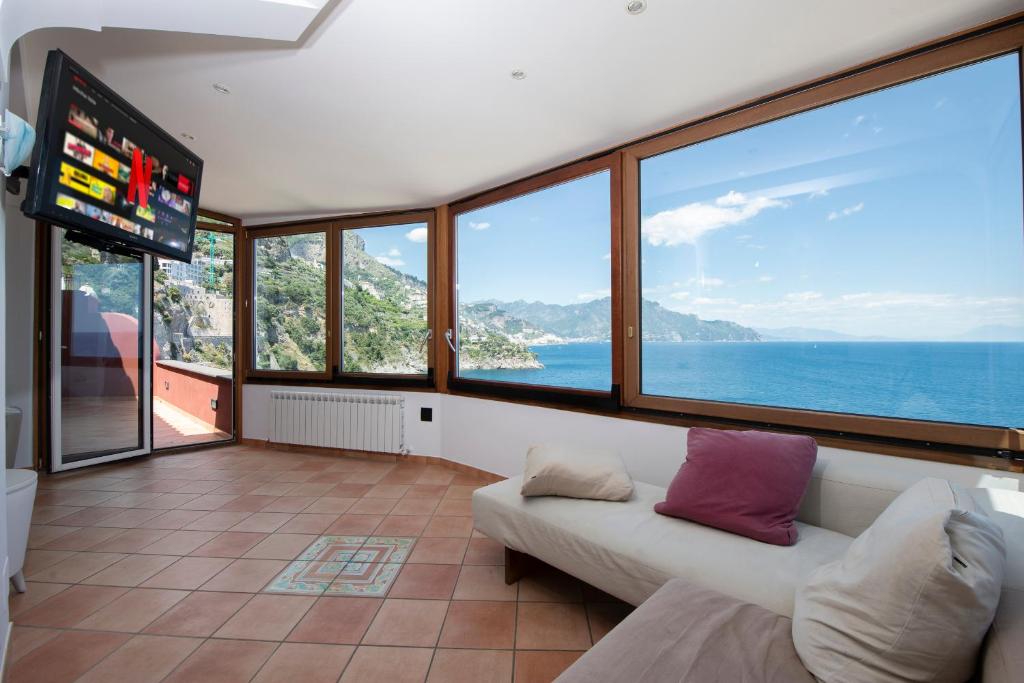 a living room with a couch and a tv at Il Sogno di Conca in Conca dei Marini